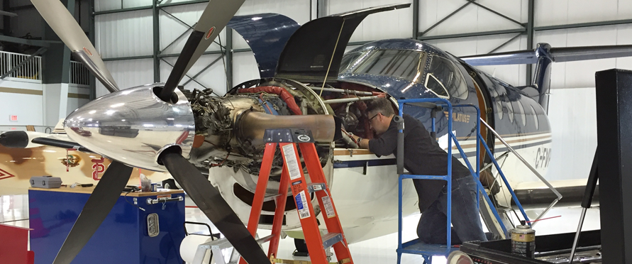 Flite Line technician performing engine maintenance on a Pilatus aircraft