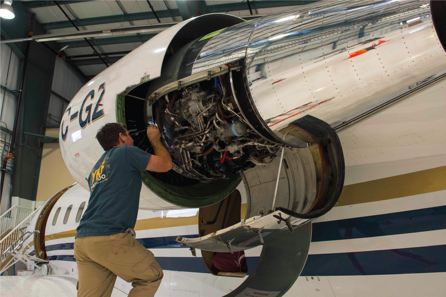 Flite Line technician performing engine maintenance on a jet aircraft